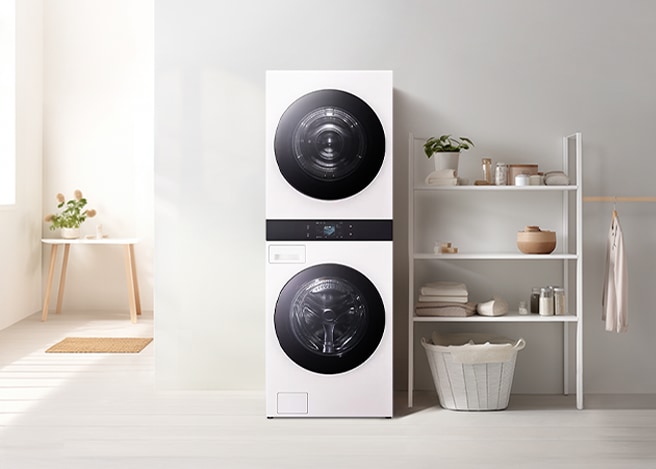 밝은 다용도실에 LG 트롬 AI 오브제컬렉션 워시타워가 중앙에 배치되어 있으며, 오른쪽 선반에는 세탁용품이 정돈되어 있습니다.